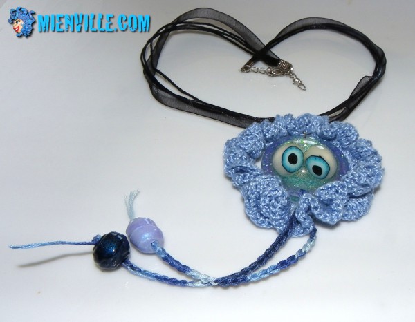 pendentif méduse en fimo et résine dans fraise au crochet, coton bleu clair